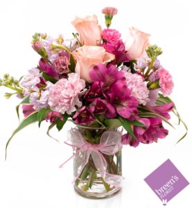 a vase of pink flowers with accents of white to make a cute design