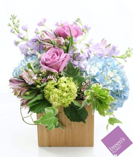 Nothing is more gorgeous than an English garden of lavender, green and blue flowers. Stock, roses, hydrangea, and delphinium complete this beautiful arrangement.