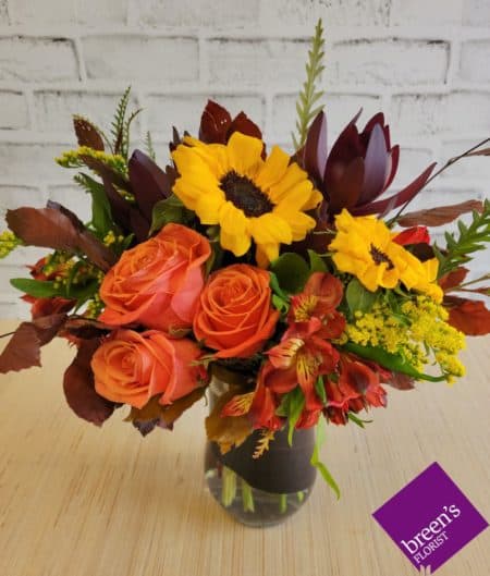 THIS DELIGHTFUL AND ABUNDANT ARRANGEMENT FEATURES ALL THE FAVORITE COLORS AND FLORALS FOR THE FALL SEASON. RICH AND WARM TONES ARE ABUNDANT WITH THIS ARRANGEMENT